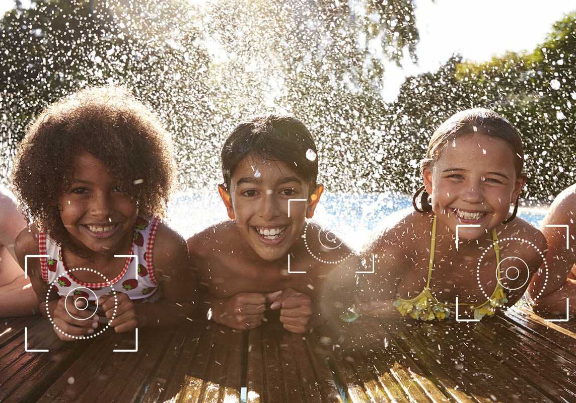 Portrait Of Children Having Fun In Outdoor Swimming Pool